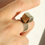 Gros plan de la bague O en argent portée sur la main, détail du serti circulaire et de la pyrite brute naturelle, Atelier Grandval.