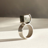 Bague O en argent 950 et pyrite brute dans un serti circulaire, vue produit fond clair, Atelier Grandval.