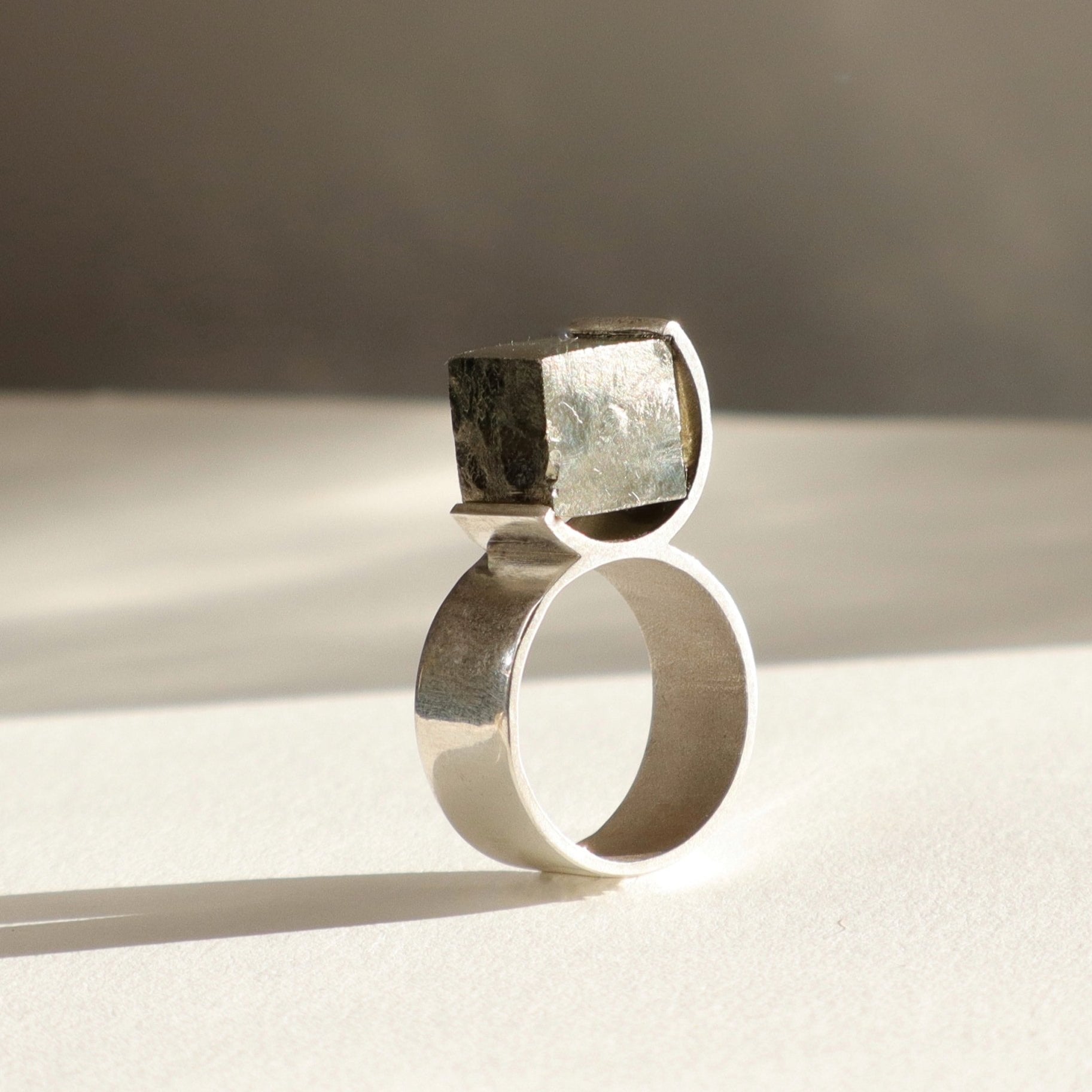 Bague O en argent 950 et pyrite brute dans un serti circulaire, vue produit fond clair, Atelier Grandval.