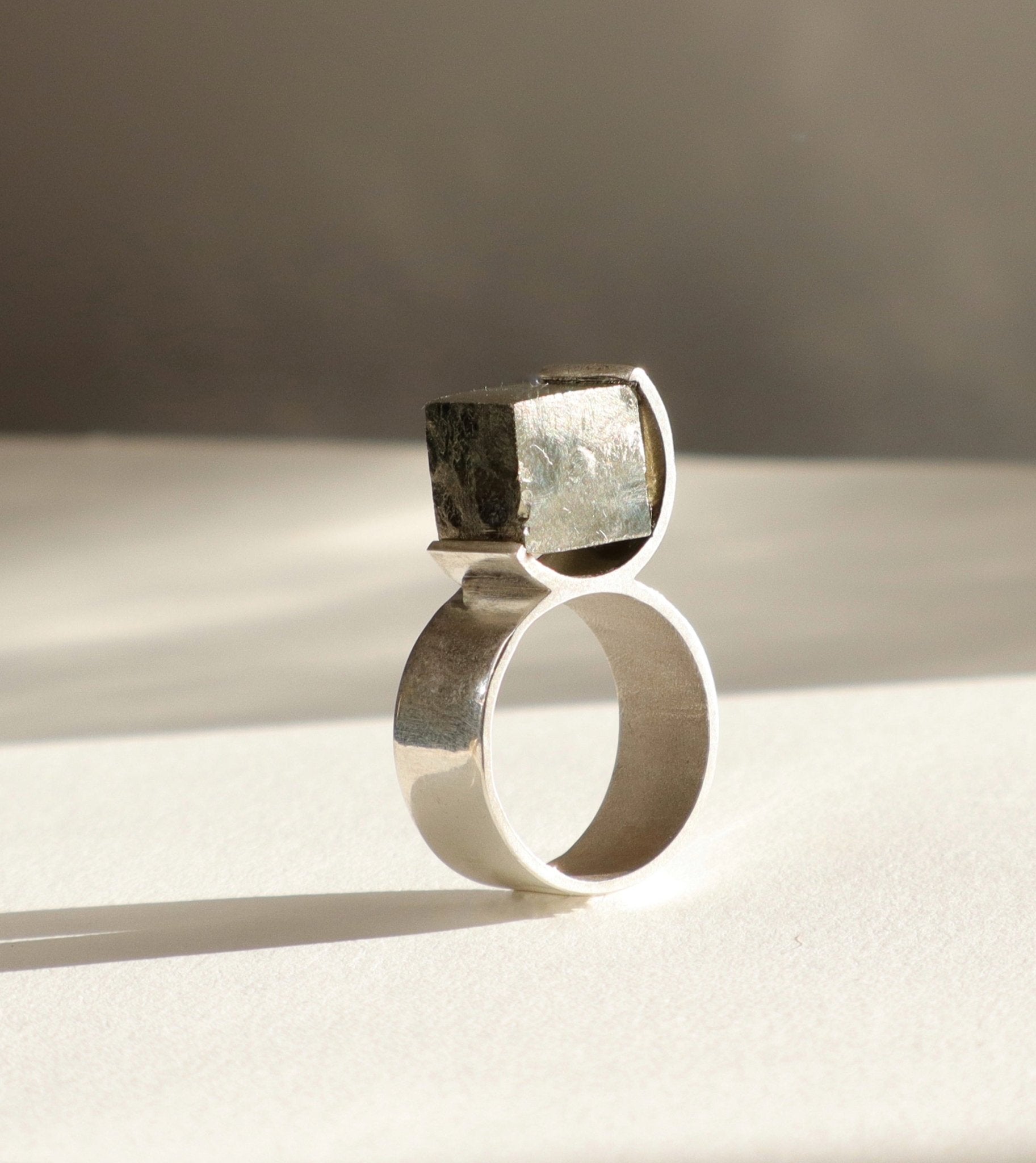 Bague O en argent 950 et pyrite brute dans un serti circulaire, vue produit fond clair, Atelier Grandval.