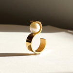 Vue de profil de la bague S montrant sa structure géométrique en vermeil et l'équilibre parfait de sa perle.