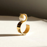 Vue de profil de la bague S montrant sa structure géométrique en vermeil et l'équilibre parfait de sa perle.