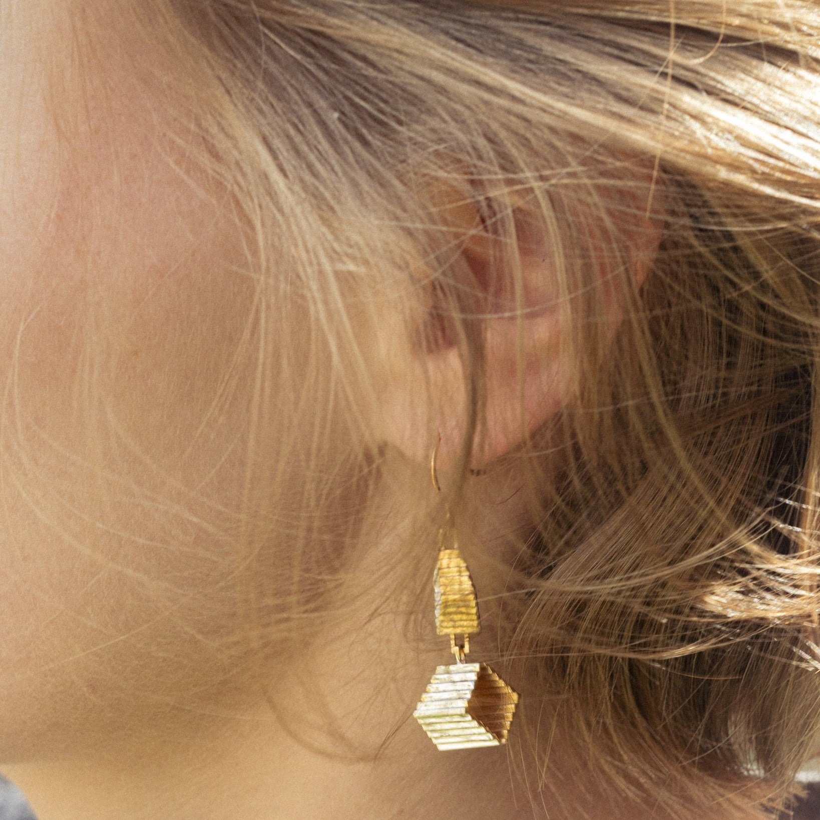 Boucles Élée en vermeil portées sur l'oreille, vue de profil, cheveux blonds, double escalier visible, Atelier Grandval.