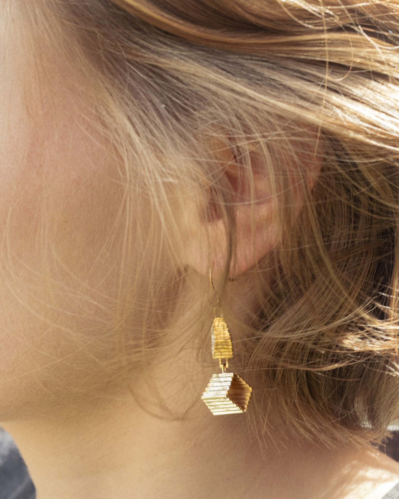 Boucles Élée en vermeil portées sur l'oreille, vue de profil, cheveux blonds, double escalier visible, Atelier Grandval.