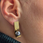 Boucles OO en vermeil portées sur l'oreille, vue de profil, perle de Tahiti 10 mm dans la monture, Atelier Grandval.