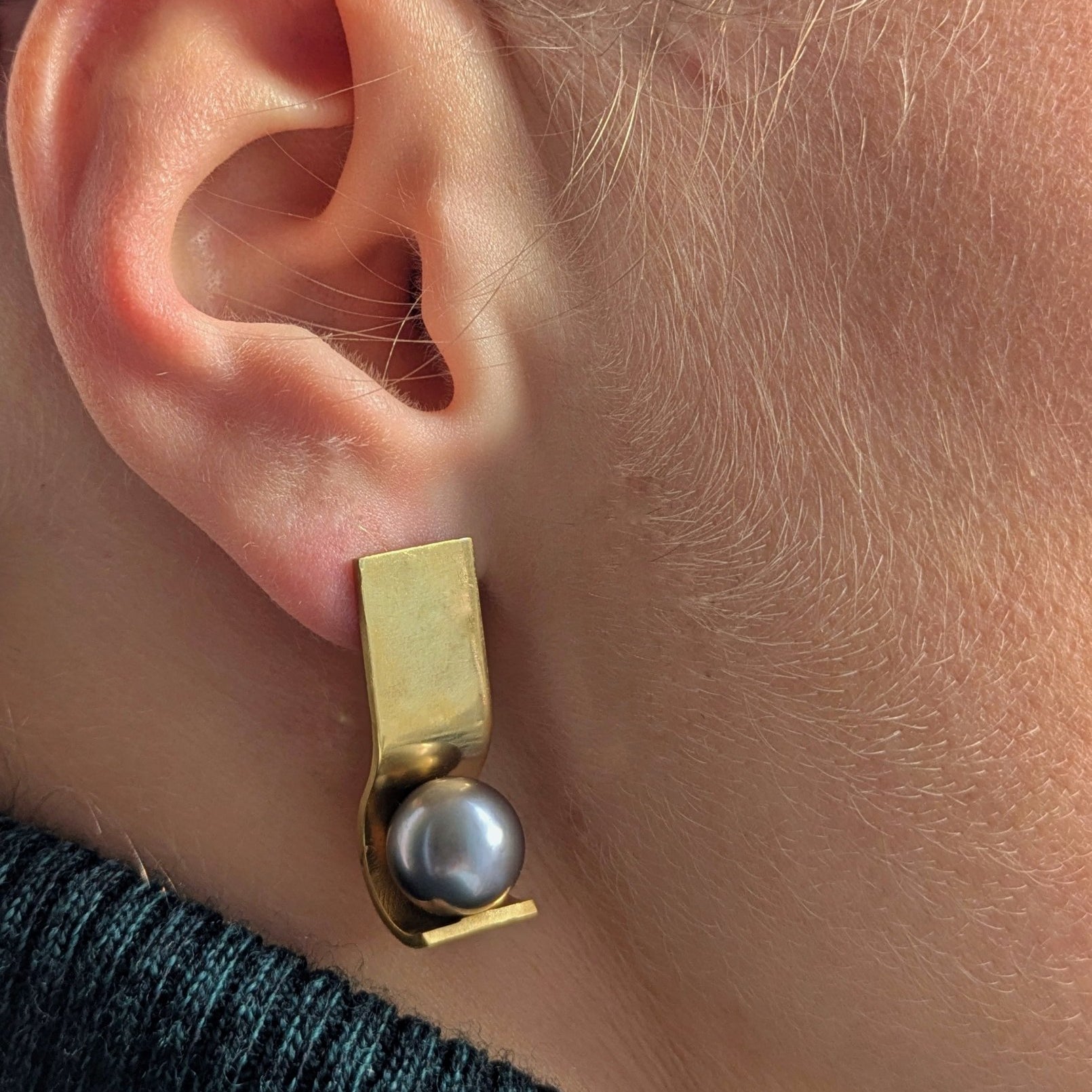 Boucles OO en vermeil portées sur l'oreille, vue de profil, perle de Tahiti 10 mm dans la monture, Atelier Grandval.