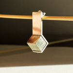 Détail de la pyrite naturelle encadrée par une monture fine en argent poli miroir, bijou de créateur fait main.