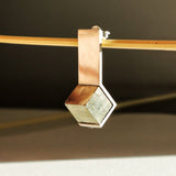 Détail de la pyrite naturelle encadrée par une monture fine en argent poli miroir, bijou de créateur fait main.