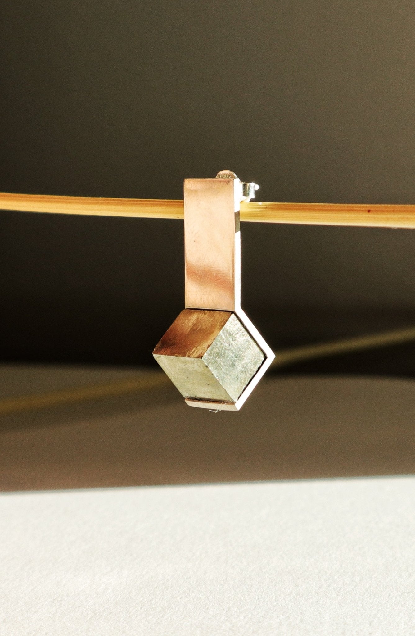 Détail de la pyrite naturelle encadrée par une monture fine en argent poli miroir, bijou de créateur fait main.